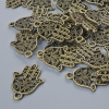 Pendente 'Hamsa' bronzo, diametro 21×15 mm, foro 1,7 mm, confezione 24 pezzi ±, colore bronzo metallico
