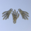Pendente a forma di mano scheletrica, colore bronzo, dimensioni 35x19x2 mm ± foro, diametro 3 mm ± confezione 20 g (circa 9 pezzi)