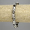 Braccialetto pietra lavica e ematite: cilindri in pietra lavica argentata chiara 12×8 mm ±, ematite sfaccettata 5,5×6 mm ±, lunghezza 18 cm ± elastico