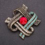 Spilla con cristallo rosso e strass azzurri e grigi, 47×59 mm, metallo giallo