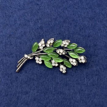 Spilla 'Ramoscello' con occhio di gatto verde, strass bianchi, metallo argentato, diametro 50x27 mm+